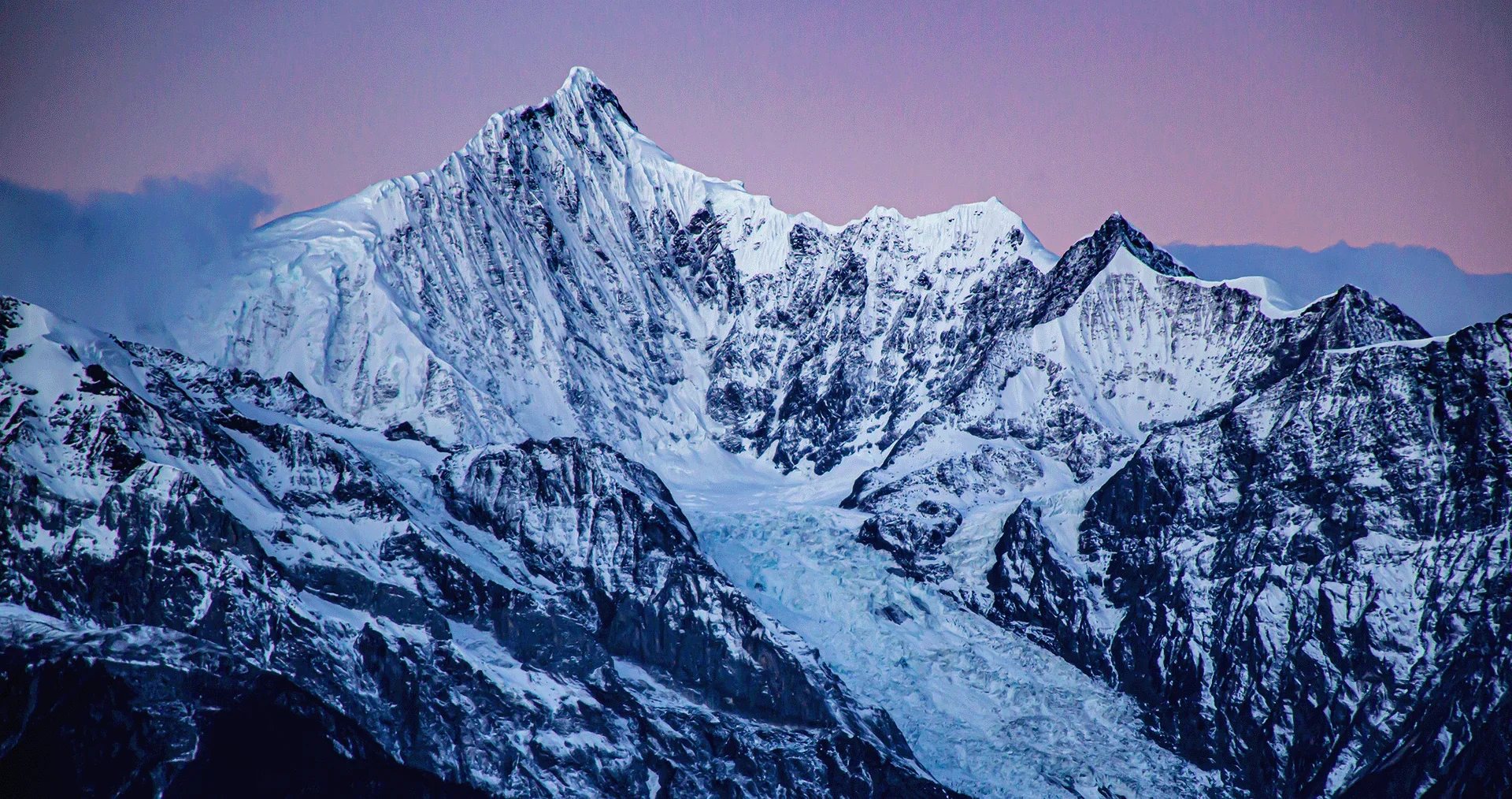 Meili Snow Mountain at dawn, the snow-capped peaks of Kawagebo rising above the clouds